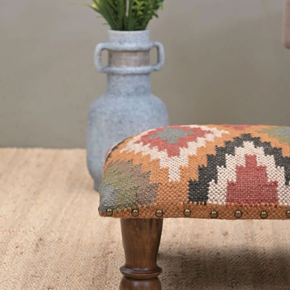 Pequeña otomana tapizada en tejido kilim romboidal
